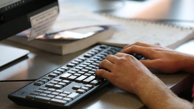 学生用手在电脑键盘上搜索.